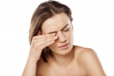 Woman rubbing tired eyes due to eye muscle fatigue and strain.