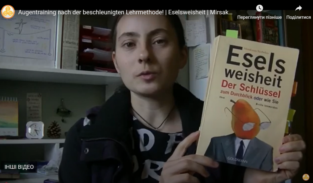 Frau hält das Buch „Eselsweisheit“ von Mirsakarim Norbekov in den Händen und präsentiert ihre Rezension zur Sehverbesserung.